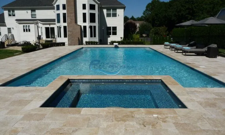 inground rectangular swimming pool with square shaped spa in backyard of a house, pool builder