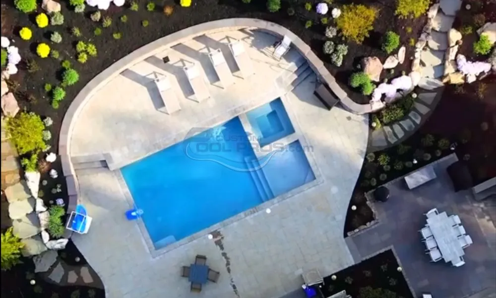 arial view of rectangular inground pool with travertine pool patio deck in backyard