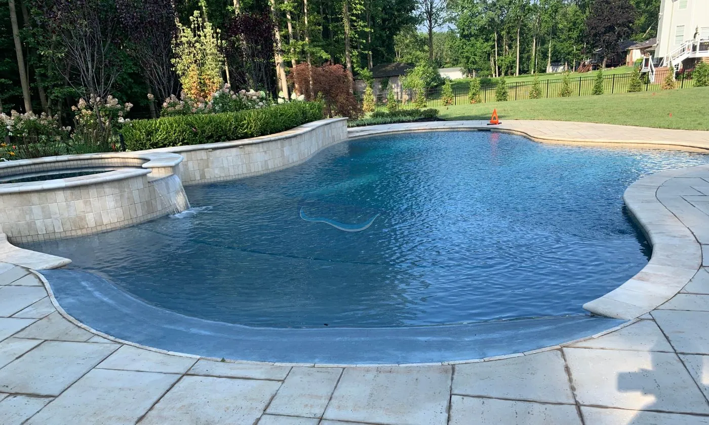 inground pool freeform design with spa, retaining wall in backyard, luxury pools builder, inground pool